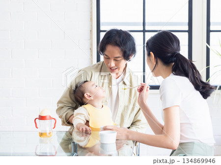 赤ちゃんに離乳食をあげる夫婦 赤ちゃんに離乳食をあげる夫婦 134869946