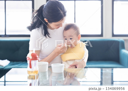 赤ちゃんに離乳食をあげるお母さん 赤ちゃんに離乳食をあげるお母さん 134869956