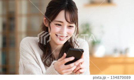 スマホを持つ若い女性（生成AI) 134870089