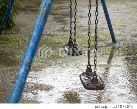 雨の日のブランコと水溜まり 134870876