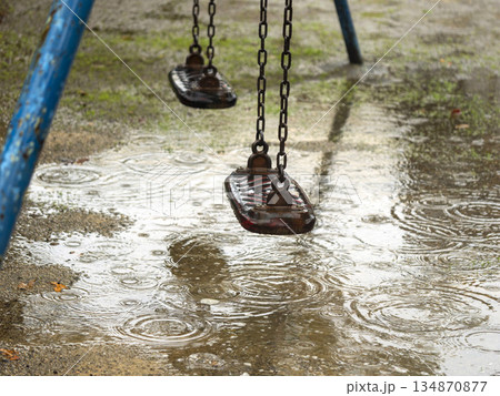 雨の日のブランコと水溜まり 134870877