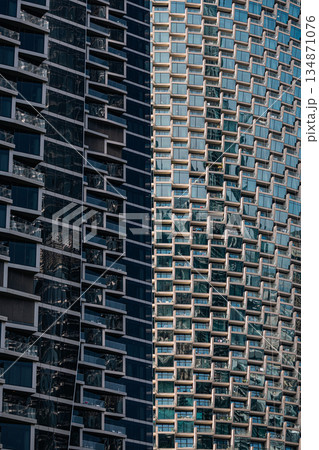 two skyscrapers with geometric glass facade and strong shadow line two skyscrapers with geometric glass facade and strong shadow line 134871076