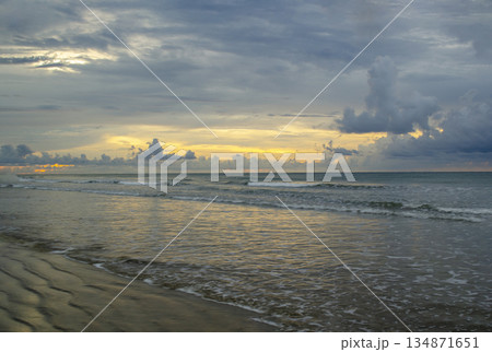 Sunset over the sea with dramatic cloud contrast and shimmering highlights across rolling waves, Kuala Penyu, Sabah, Malaysia. 134871651