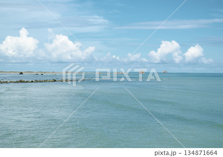 Clear turquoise water scene with distant horizon and fluffy clouds floating above the sea, Kuala Penyu, Sabah, Malaysia. Clear turquoise water scene with distant horizon and fluffy clouds floating above the sea, Kuala Penyu, Sabah, Malaysia. 134871664