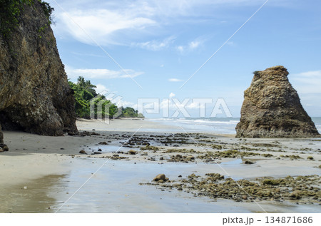 Coastal panorama with sea stack near shore, cliffs framing the left side, and calm reflective water, Kuala Penyu, Sabah, Malaysia. Coastal panorama with sea stack near shore, cliffs framing the left side, and calm reflective water, Kuala Penyu, Sabah, Malaysia. 134871686