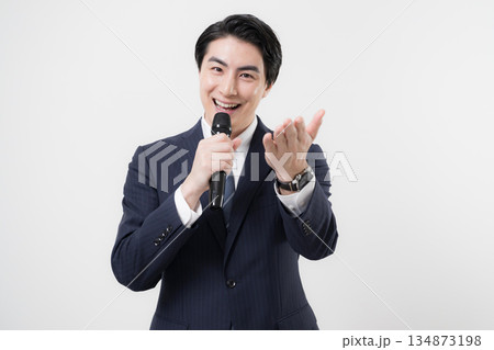 マイクを持ってインタビューを促す司会者や取材などのビジネスマン　プレゼンやアナウンサーなどのイメージ 134873198