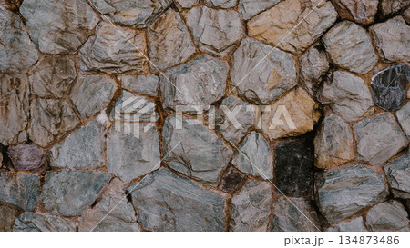 Weathered granite stone wall texture background with rustic irregular masonry Weathered granite stone wall texture background with rustic irregular masonry 134873486