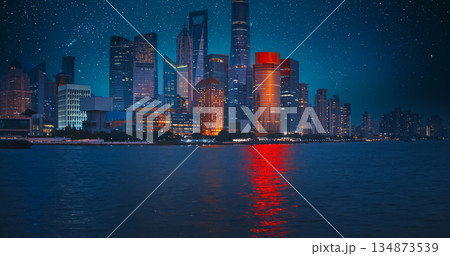 Night starry sky above Shanghai Skyscrapers. reflection of Shanghai's skyscrapers amidst bustling urban life at evening. 134873539