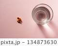 コップの水とカプセル（服薬の準備） 134873630