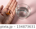 手のひらのカプセルと水（服用シーン） 134873631