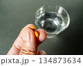 服薬直前：手に錠剤と水のグラス 134873634
