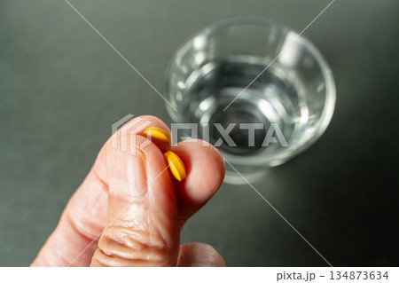 服薬直前：手に錠剤と水のグラス 134873634