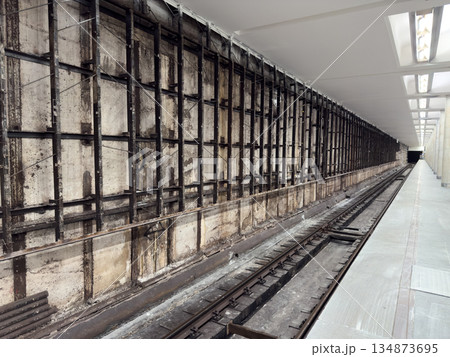 Metro platform in tunnel with broken wall. Wall renovation at metro station. Repairing wall in tunnel. Not finished station under construction. Concept for new station. Renovating old station Metro platform in tunnel with broken wall. Wall renovation at metro station. Repairing wall in tunnel. Not finished station under construction. Concept for new station. Renovating old station 134873695