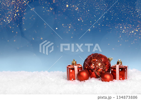 Christmas tree baubles on blue background with white snow and golden lights. Festive winter holiday background. Design with copy space for greeting card, text, advertising, banner, invitation 134873886