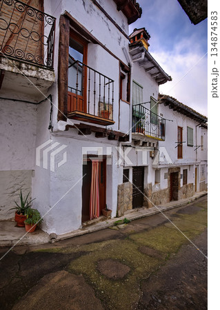 Quiet white hillside street with balconies and rustic doors in a Mediterranean village Quiet white hillside street with balconies and rustic doors in a Mediterranean village 134874583