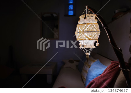 Warm hanging lantern illuminates a cozy interior with beaded, handcrafted detail for home decor 134874637