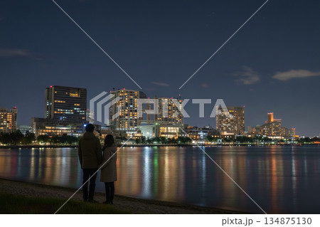 お台場の夜景を眺めながらデートを楽しむ若いカップルの後ろ姿 お台場の夜景を眺めながらデートを楽しむ若いカップルの後ろ姿 134875130