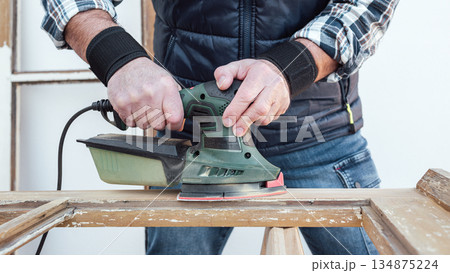 Carpenter at work, restoring an old wooden window. Carpentry. 134875224
