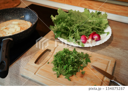 A bunch of red radishes are displayed on a green leaf. The radishes are fresh and ready to be eaten 134875287