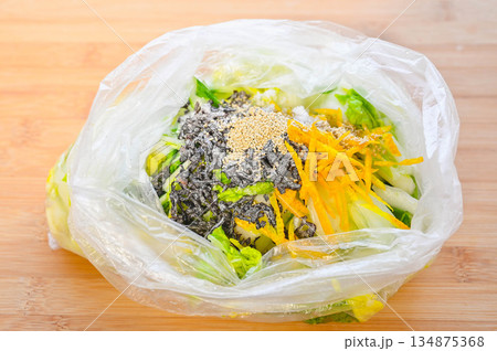 白菜の浅漬けに柚子と塩昆布と調味料を加える 134875368