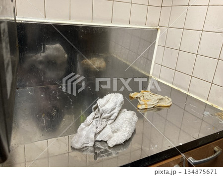 ステンレスの調理台を布巾で拭き掃除するキッチンの風景 134875671