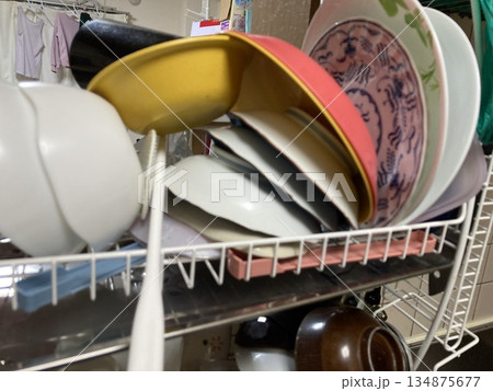 水切りラックに積み重なった洗った後の大量の食器やボウル 水切りラックに積み重なった洗った後の大量の食器やボウル 134875677