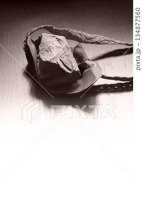 Sling with stone on wooden background Sling with stone on wooden background 134877560