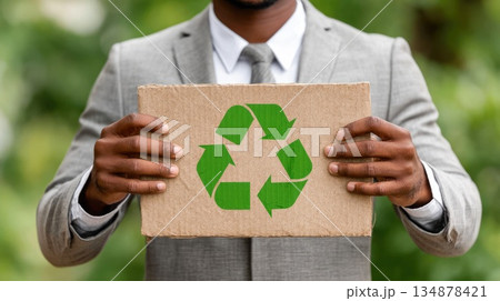 Businessman Holding Cardboard Sign with Green Recycling Symbol 134878421