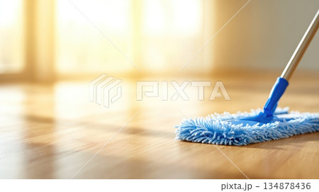 Cleaning Wooden Floor with Blue Mop in Sunlit Modern Interior Cleaning Wooden Floor with Blue Mop in Sunlit Modern Interior 134878436