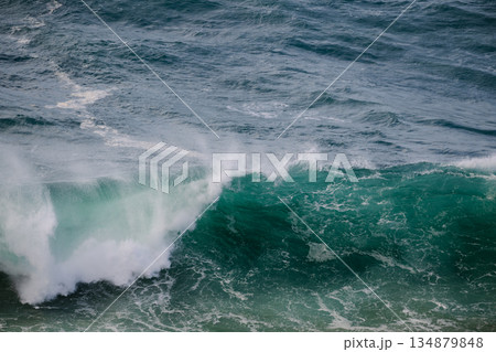Powerful turquoise ocean wave curling toward shore with spray and foam Powerful turquoise ocean wave curling toward shore with spray and foam 134879848