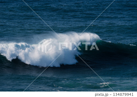 Powerful ocean wave curling and crashing in the deep blue sea Powerful ocean wave curling and crashing in the deep blue sea 134879941
