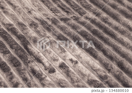 Close-up shot of plush beige fabric showing deep folds and soft texture 134880010