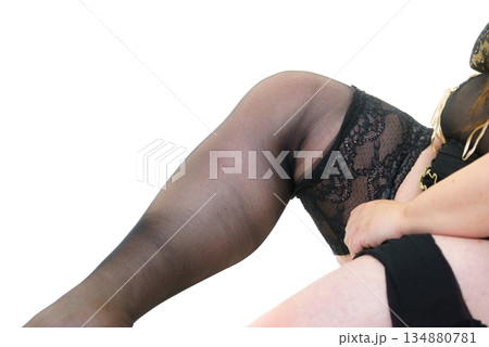 Woman plus size puts on black nylon stockings 134880781