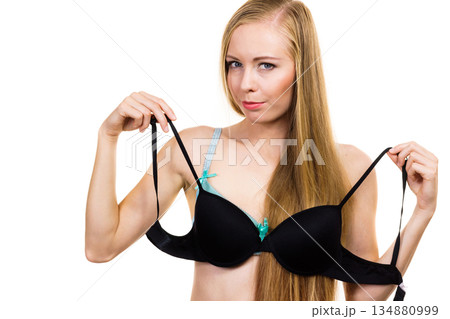 Woman trying on black pushup bra 134880999