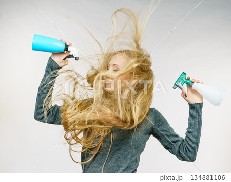 Female messy long hair holds spray bottle Female messy long hair holds spray bottle 134881106
