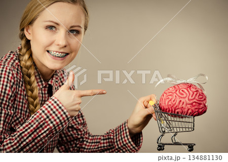 Woman holding shopping cart with brain 134881130