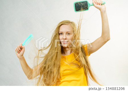 Girl blowing hair with comb brush Girl blowing hair with comb brush 134881206