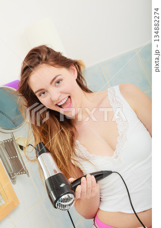 long haired woman drying hair in bathroom long haired woman drying hair in bathroom 134882274