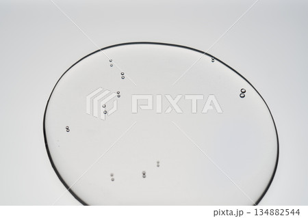 Clear liquid droplet with bubbles on grey background 134882544