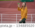 A woman drinking water at the stadium 134885020
