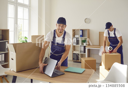 Young mover man packing laptop for moving, individual or company worker job moving office things Young mover man packing laptop for moving, individual or company worker job moving office things 134885508