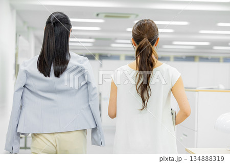 オフィスで歩きながら話す女性 オフィスで歩きながら話す女性 134888319