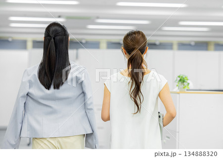 オフィスで歩きながら話す女性 オフィスで歩きながら話す女性 134888320