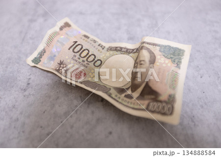 しわくちゃになって落ちている1万円札 しわくちゃになって落ちている1万円札 134888584