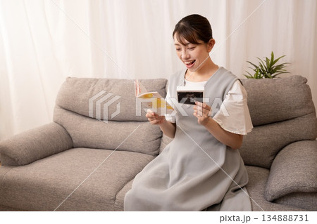 母子手帳とエコー写真を見る妊婦の女性 134888731