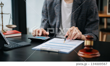 Women counting coins on calculator taking from the piggy bank. hand holding pen working on calculator to calculate on desk about cost at home office. Women counting coins on calculator taking from the piggy bank. hand holding pen working on calculator to calculate on desk about cost at home office. 134889567