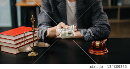 justice and law concept.passing bribe money in the envelop at lawyer office. businessman hand taking bribe money from female 134889586