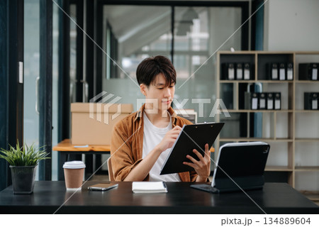 Portrait of a young man sitting at his desk in the office. Portrait of a young man sitting at his desk in the office. 134889604