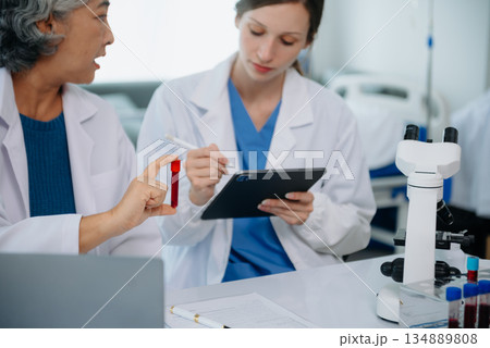 Scientist team meeting and writing analysis results in the laboratory study and analyze scientific sample Scientist team meeting and writing analysis results in the laboratory study and analyze scientific sample 134889808