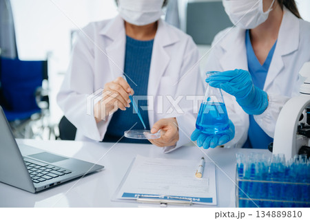 Scientist team meeting and writing analysis results in the laboratory study and analyze scientific sample Scientist team meeting and writing analysis results in the laboratory study and analyze scientific sample 134889810